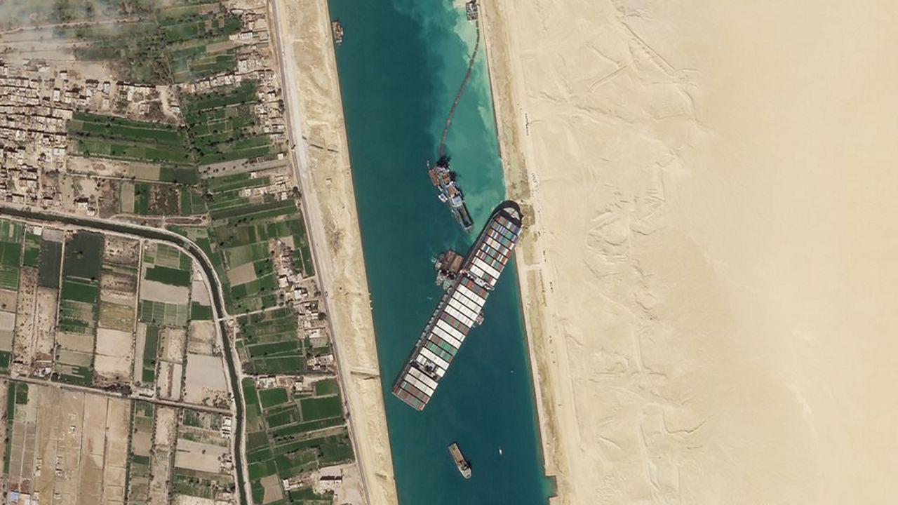 In this March 28, 2021, satellite file image from Planet Labs Inc, the cargo ship MV Ever Given sits stuck in the Suez Canal near Suez, Egypt. Consumers may face shortages and higher prices for electronics, toys, furniture and other goods should attempts to free the mammoth container ship stuck in Egypt’s Suez Canal drag on several weeks. (Planet Labs Inc. via AP)