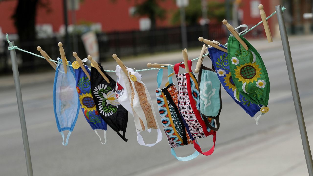 Homemade face masks for sale blow in the wind outside of a business, Tuesday, May 12, 2020, in San Antonio. (AP Photo/Eric Gay)