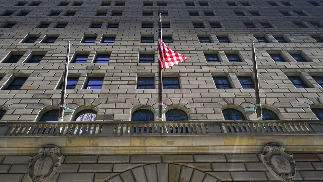 The American flag is tangled up flying outside the Federal Reserve Bank of New York building, Tuesday, Sept. 27, 2022, in the Financial District of New York. (AP Photo/Mary Altaffer)