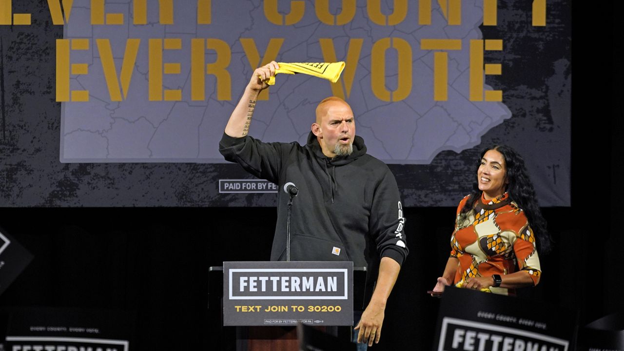 Pennsylvania Lt. Gov. John Fetterman, the Democratic nominee for the state's U.S. Senate seat, waves a towel after being introduced by wife Gisele Barreto Fetterman, right, during a rally in Erie, Pa., on Friday, Aug. 12, 2022. (AP Photo/Gene J. Puskar)