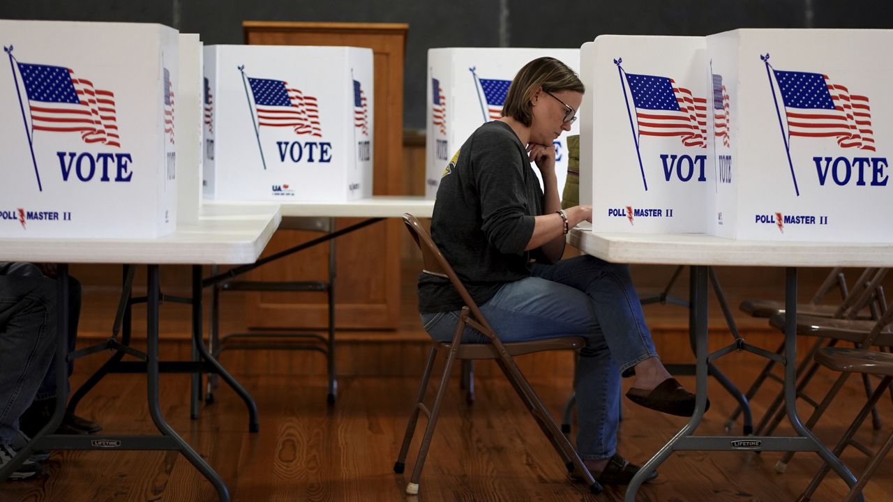 A woman votes at a school in rural Perry, Kan., on Tuesday, Nov. 5, 2024. (AP Photo/Charlie Riedel)