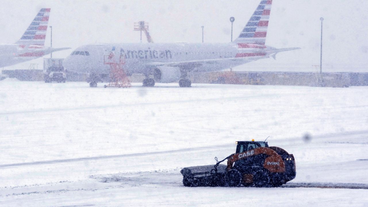 Snow and ice are cleared from the tarmac at Dallas Fort Worth International Airport in Grapevine, Texas, Thursday, Feb. 3, 2022. (AP Photo/LM Otero)