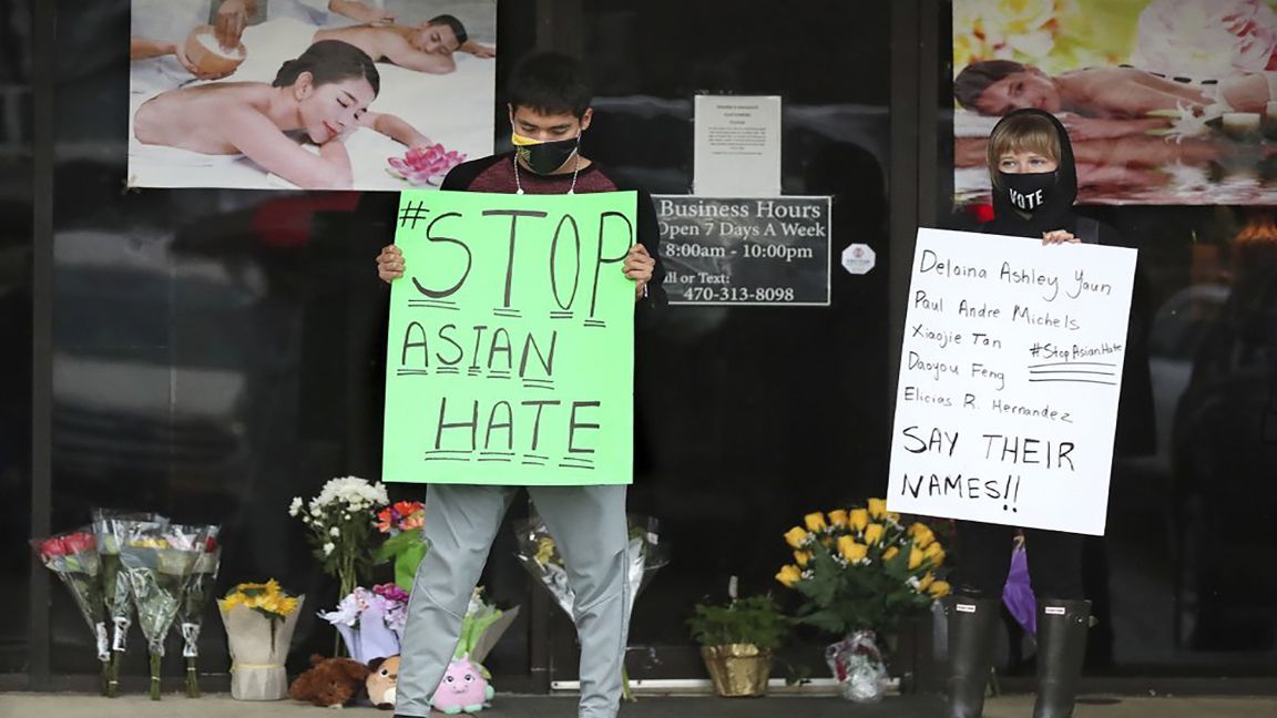 In this March 17, 2021, file photo, after dropping off flowers Jesus Estrella, left, and Shelby stand in support of the Asian and Hispanic community outside Young's Asian Massage in Acworth, Ga. The murder case against Robert Aaron Long, a white man accused of shooting and killing six women of Asian descent and two other people at Atlanta-area massage businesses, could become the first big test for Georgia’s new hate crimes law. (Curtis Compton /Atlanta Journal-Constitution via AP, File)