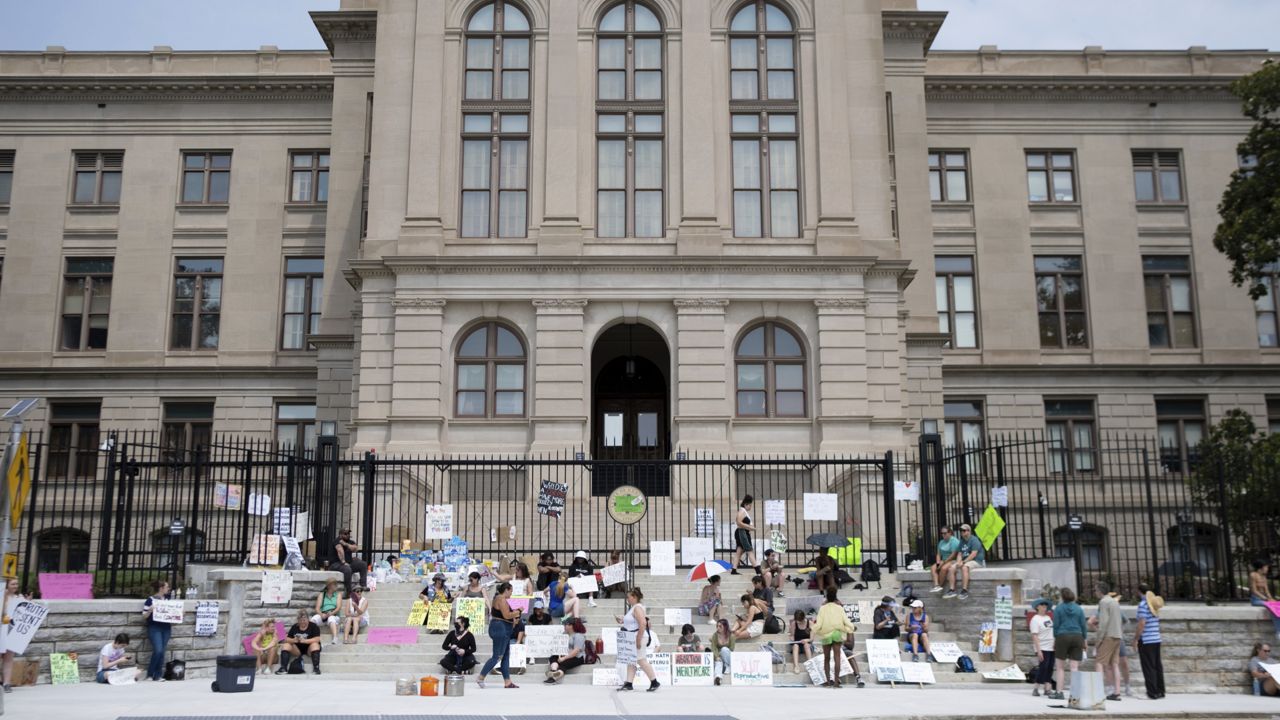 A small group gathers at the steps of the Georgia State Capitol protesting the overturning of Roe v. Wade on Sunday, June 26, 2022. (AP Photo/Ben Gray)