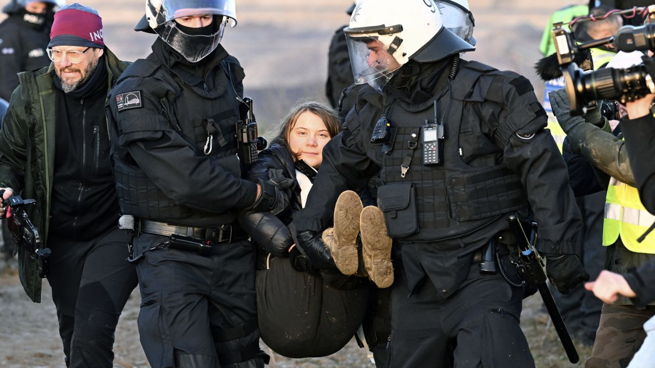 Police officers carry Swedish climate activist Greta Thunberg away from the edge of the Garzweiler II opencast lignite mine during a protest action by climate activists after the clearance of Luetzerath, Germany, Tuesday, Jan. 17, 2023. (Federico Gambarini/dpa via AP)