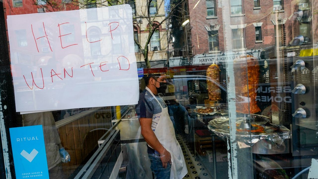 A Help Wanted sign hangs in the window of a restaurant in the Greenwich Village neighborhood of Manhattan in New York, Tuesday, May 4, 2021 Some restaurants in New York City are starting to hire employees now that they can increase their indoor dining to 75% of capacity starting May 7. (AP Photo/Mary Altaffer)