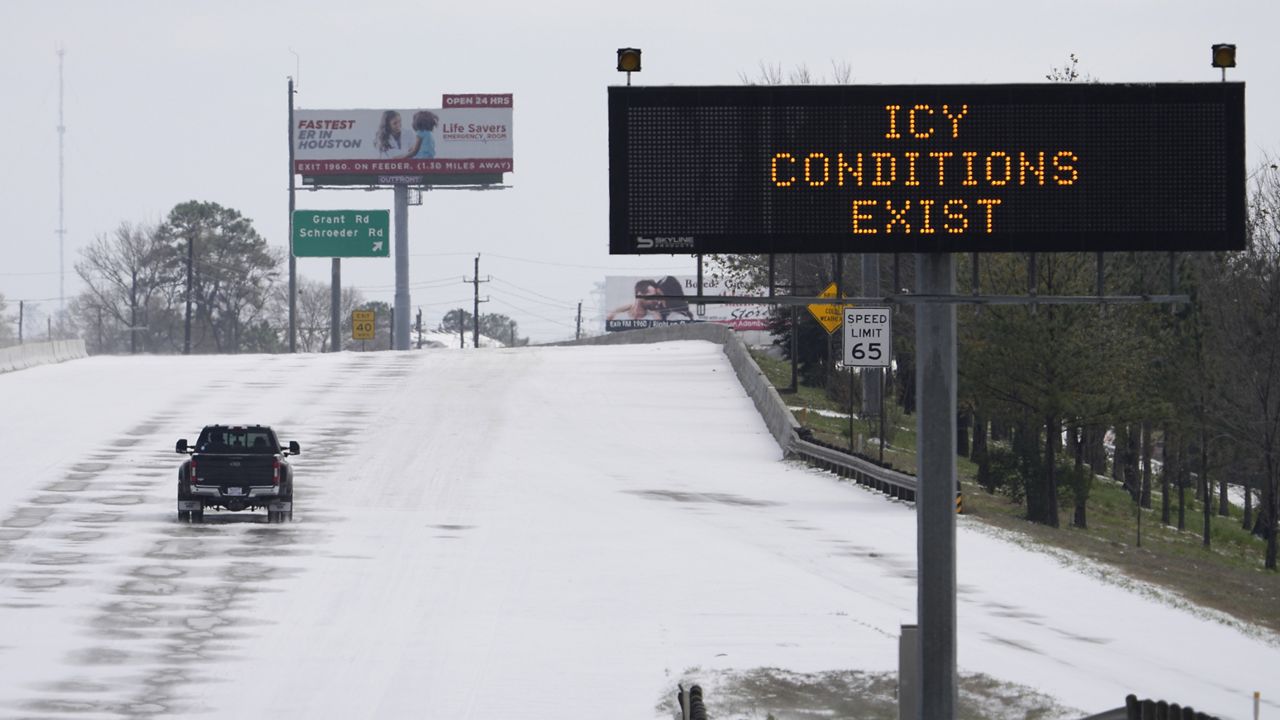 A truck drives past a highway sign Monday, Feb. 15, 2021, in Houston. (AP Photo/David J. Phillip)