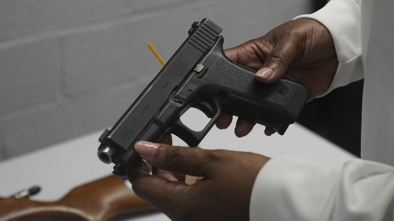 FILE - In this May 22, 2021, file photo a handgun from a collection of illegal guns is reviewed during a gun buyback event in Brooklyn, N.Y. (AP Photo/Bebeto Matthews, FIle)