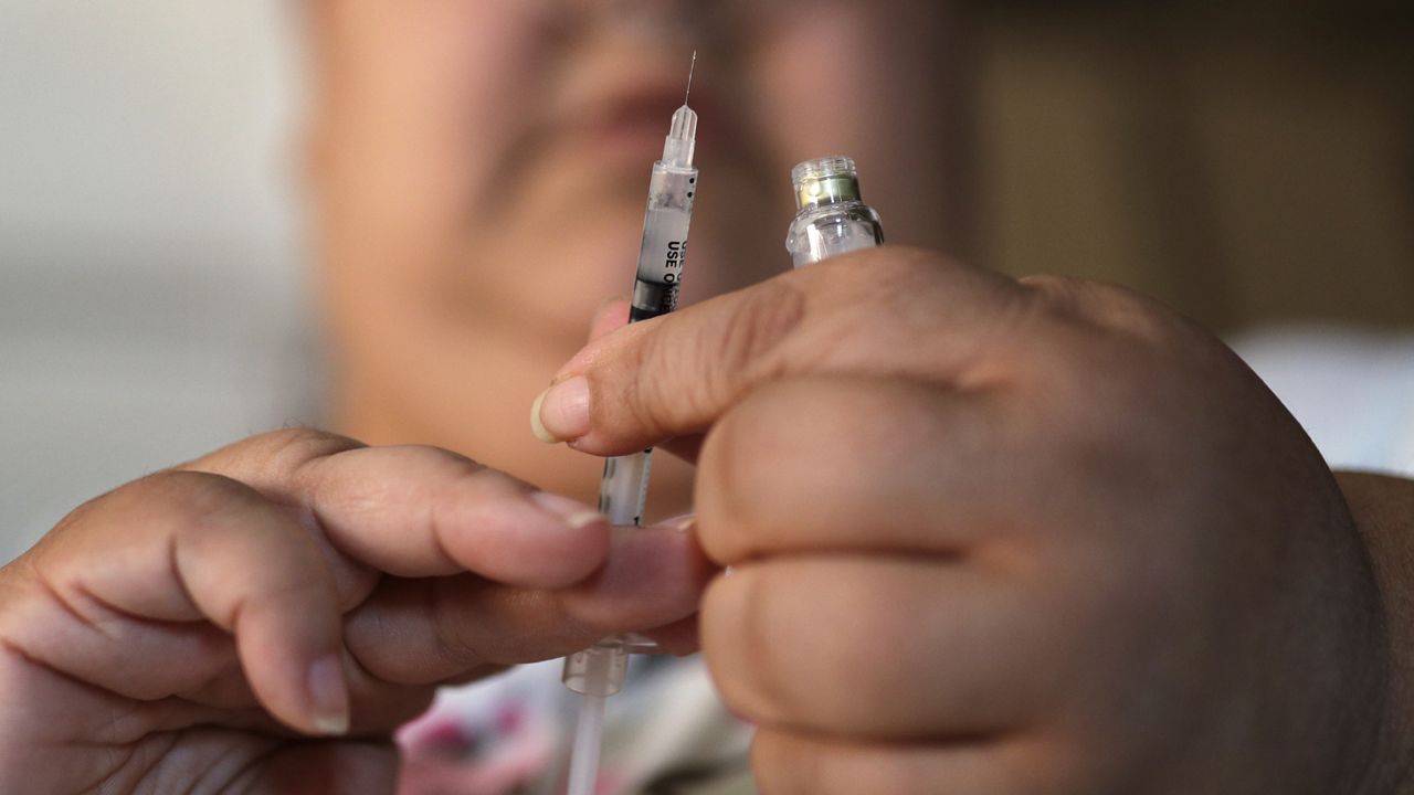 In this April 18, 2017 file photo, a woman with Type 2 diabetes prepares to inject herself with insulin at her home in Las Vegas. Overweight or obese Americans should start getting screened for diabetes and prediabetes earlier, at age 35 instead of 40, according to national guidelines updated on Tuesday, Aug. 24, 2021. (AP Photo/John Locher)