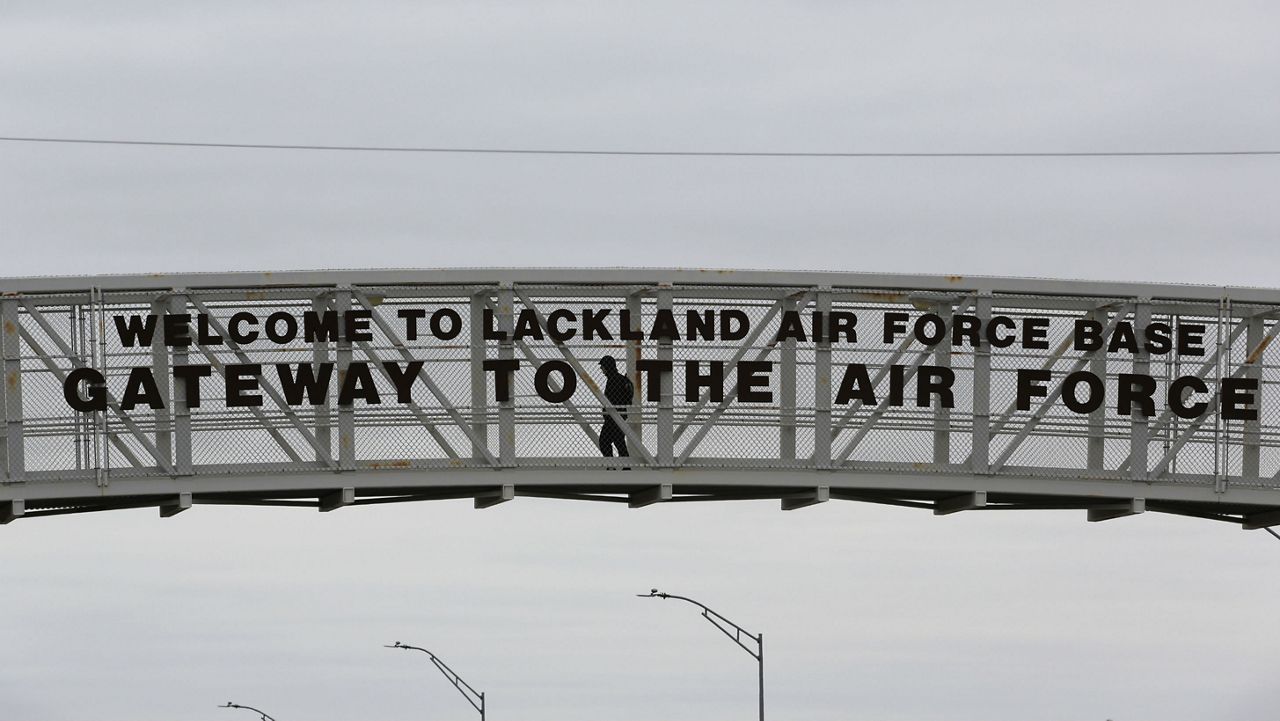 FILE - A pedestrian uses a walkway at the main gate at Lackland Air Force Base in San Antonio, Wednesday, Feb. 5, 2020. Several planes carrying U.S. citizens fleeing the virus zone in Wuhan China arrived at Air Force bases including Joint Base San Antonio-Lackland, according to the CDC. (AP Photo/Eric Gay)