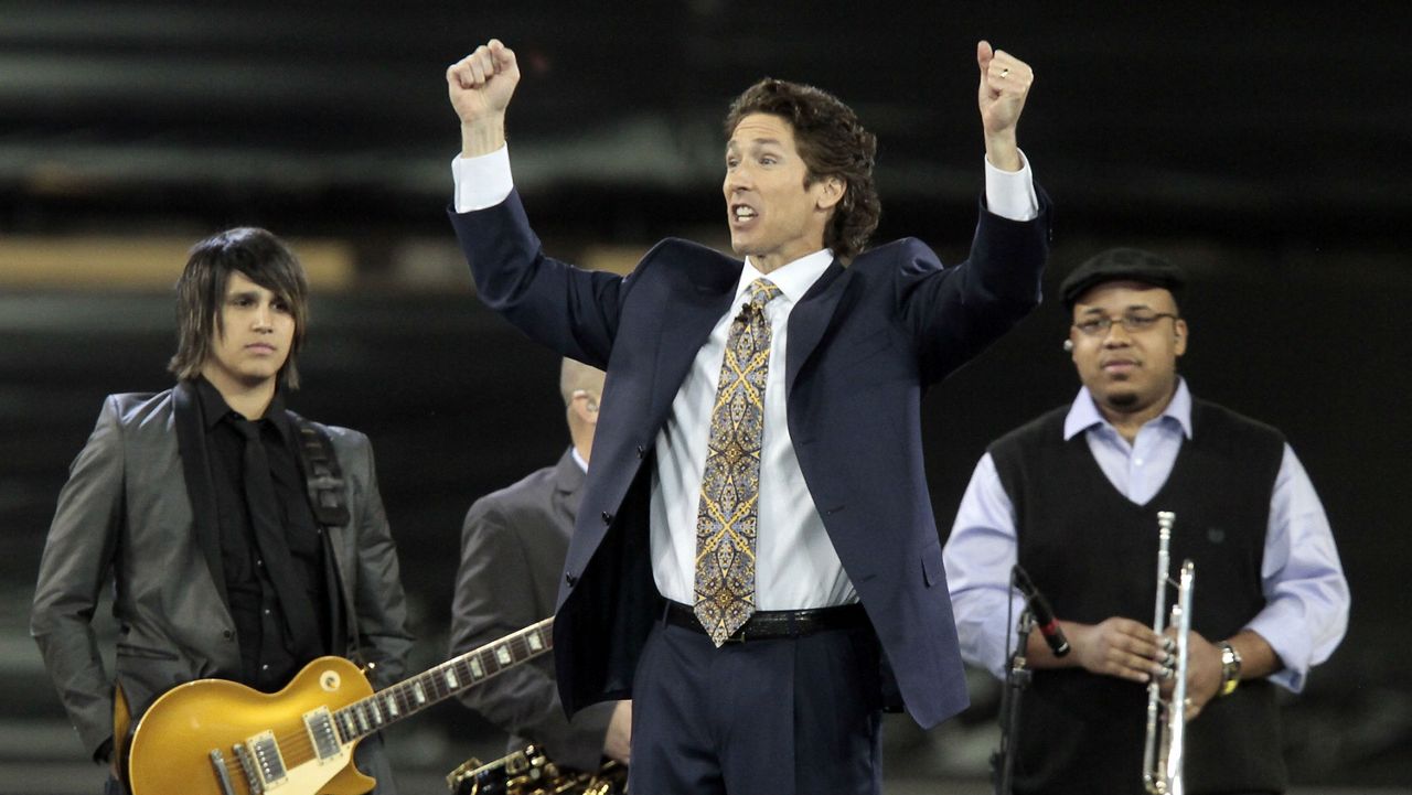 FILE - Lakewood Church pastor Joel Osteen, center, leads his congregation in prayer during his "A Night of Hope" event at Dodger Stadium on Saturday April 24, 2010. (AP Photo/Richard Vogel)
