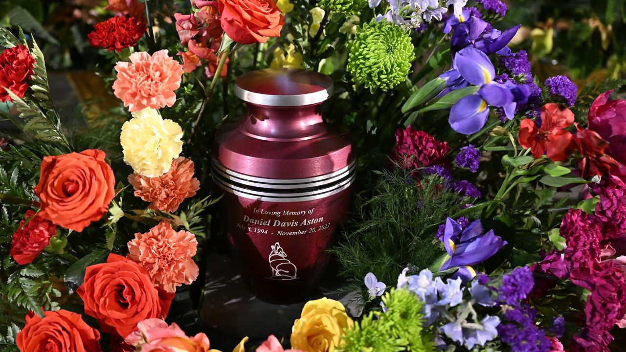 A cremation urn with Daniel Aston's ashes is surrounded by flowers during a memorial service held at Shove Memorial Chapel on the Colorado College's campus on Dec. 7, 2022, in Colorado Springs, Colo. (RJ Sangosti/The Denver Post via AP, Pool)