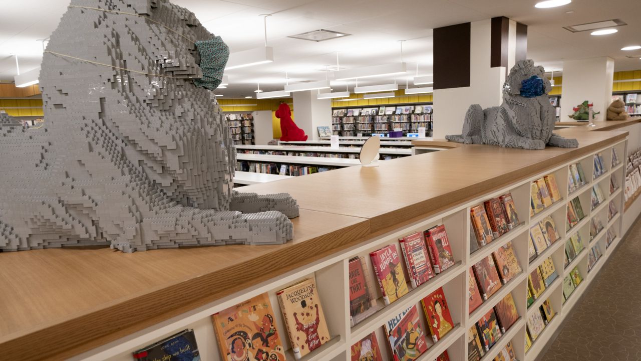 FILE: Lions, made with Legos, sit atop book shelves in the children's section of the Stavros Niarchos Foundation Library, Tuesday, June 1, 2021, in New York. (AP Photo/Mark Lennihan)
