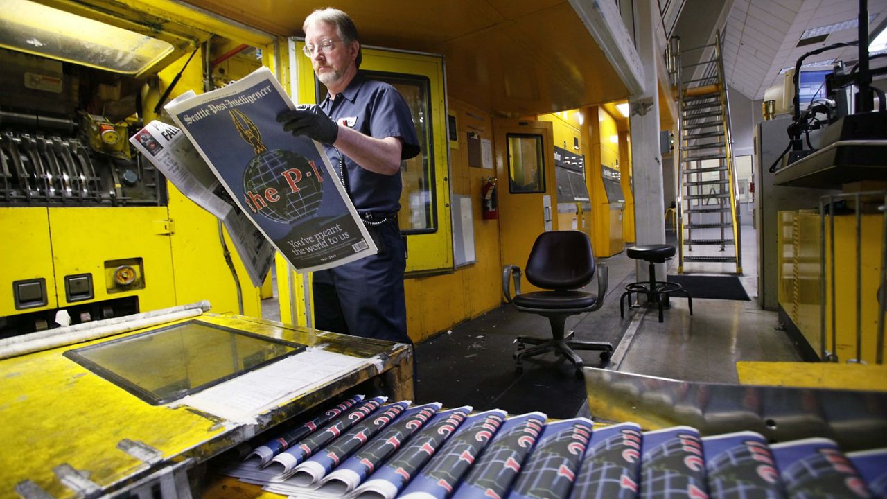 Pressman Jim Herron looks over a final edition of the Seattle Post-Intelligencer as it comes off the press on March 16, 2009, at the printing plant in Bothell, Wash. The 146-year-old paper printed its final edition on March 17, 2009. (AP Photo/Elaine Thompson)