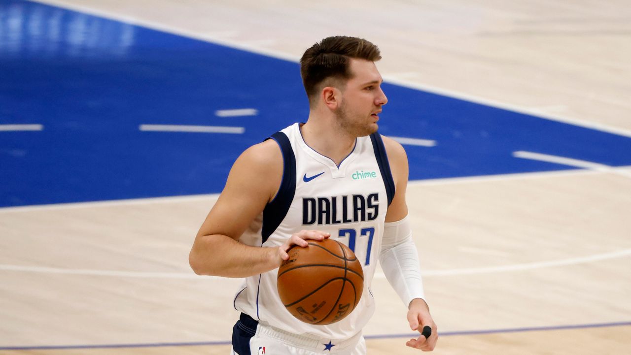 Dallas Mavericks guard Luka Doncic (77) moves the ball up the court during the first half of an NBA basketball game in Dallas, Sunday, Feb. 14, 2021. (AP Photo/Michael Ainsworth)