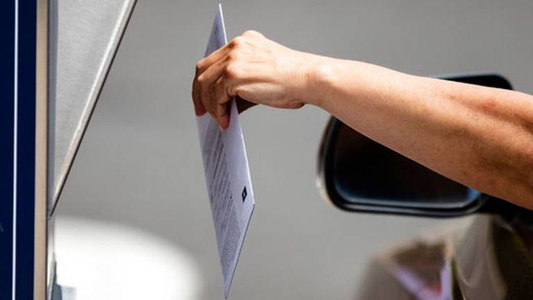 A person holds a mail-in ballot (AP Images)