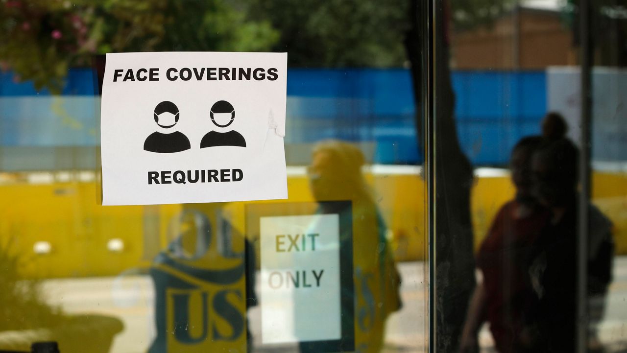 A sign that reads "Face coverings required." (Associated Press)