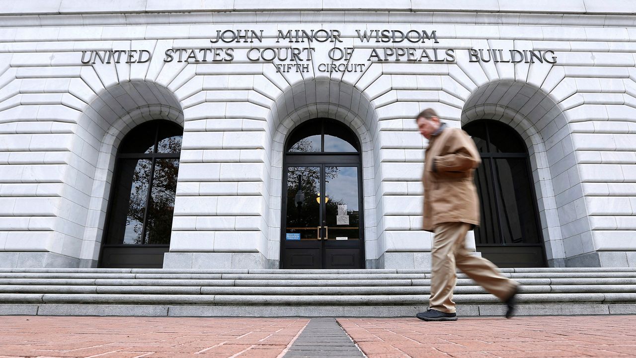 In this Jan. 7, 2015, file photo, a man walks in front of the 5th U.S. Circuit Court of Appeals in New Orleans. Texas should be allowed to halt a common second-trimester abortion procedure, the state's lawyers told a federal appeals court Thursday, Jan. 21, 2021, in a hearing punctuated by debates over fetal pain and the rights of women to medically safe abortion. (AP Photo/Jonathan Bachman, File)