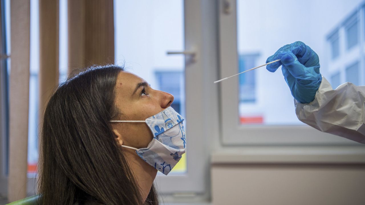 FILE: A medical student takes a nose swab sample for the novel coronavirus COVID-19 from a staff member Monday, Nov. 30, 2020. (Zoltan Balogh/MTI via AP)