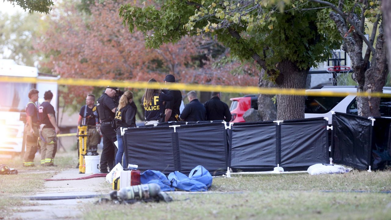 Police and firefighters investigate the scene of a house fire with multiple fatalities in Broken Arrow, Okla., outside Tulsa, Thursday, Oct. 27, 2022. (Ian Maule/Tulsa World via AP)