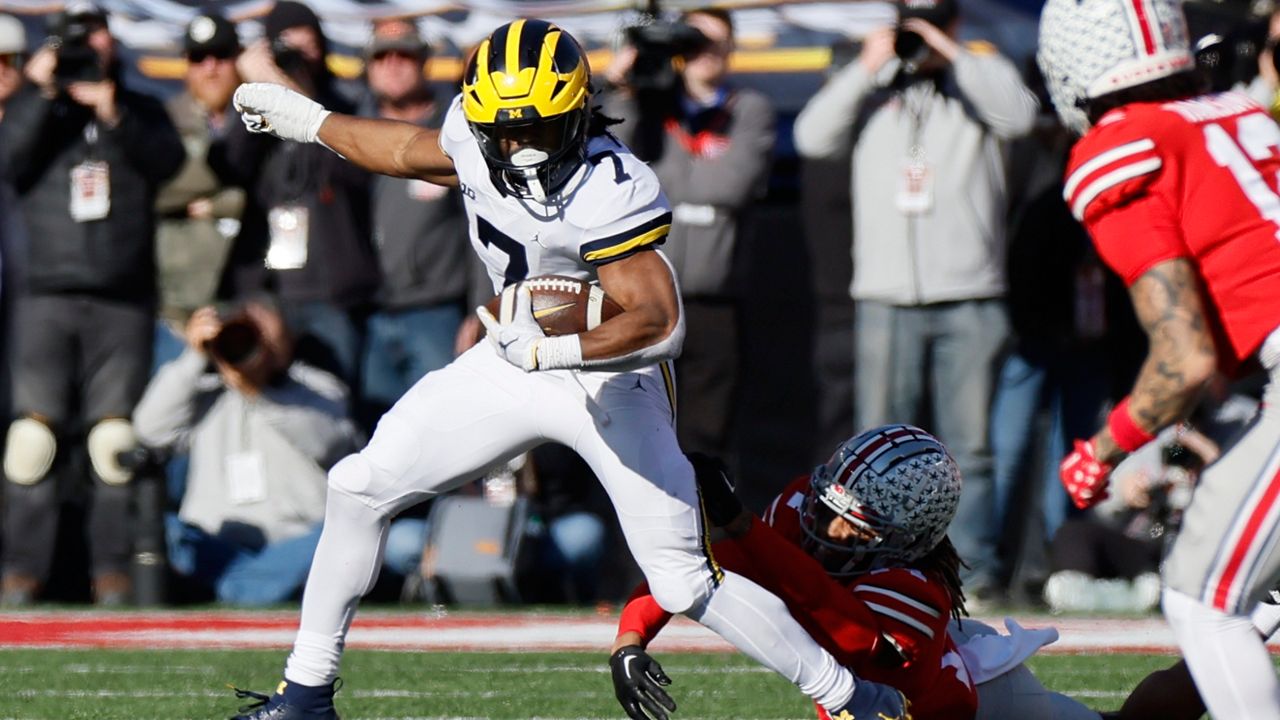 Ohio State defensive back Ronnie Hickman, right, tries to tackle Michigan running back Donovan Edwards during the first half of an NCAA college football game on Saturday, Nov. 26, 2022, in Columbus, Ohio. 