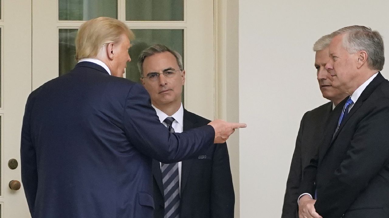 President Donald Trump, left, speaks with White House counsel Pat Cipollone, national security adviser Robert O'Brien and White House chief of staff Mark Meadows outside the Oval Office of the White House after visiting the Supreme Court to pay respects to Justice Ruth Bader Ginsburg, Thursday, Sept. 24, 2020, in Washington. (AP Photo/Patrick Semansky)