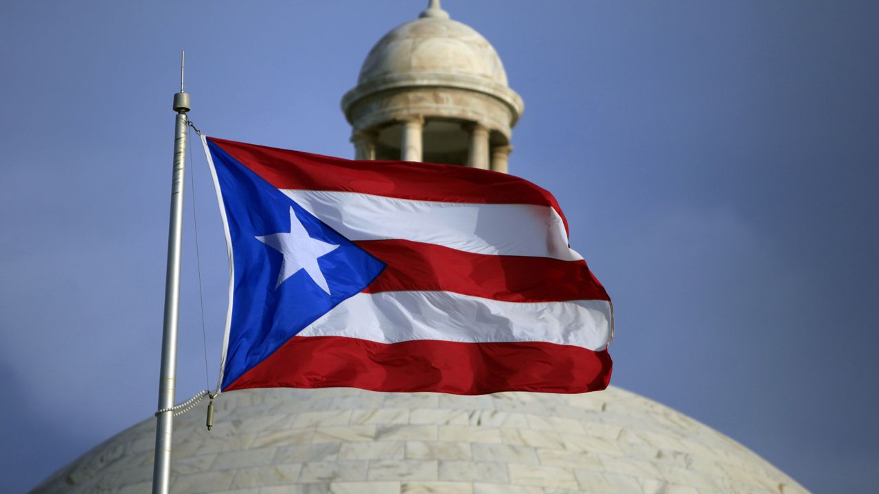 FILE - The Puerto Rican flag flies in front of Puerto Rico's Capitol as in San Juan, Puerto Rico, July 29, 2015. (AP Photo/Ricardo Arduengo, File)