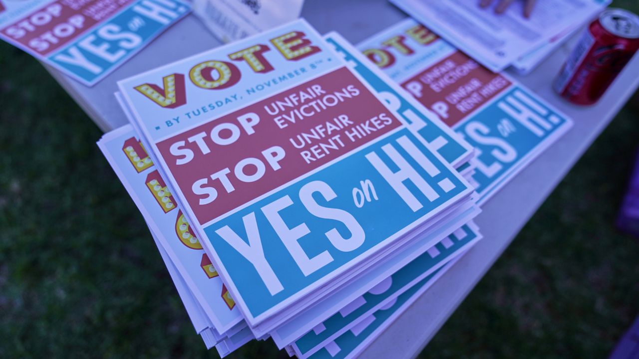 Flyers for the Yes on Measure H! campaign are distributed at La Pintoresca Park in Pasadena, Calif., Saturday, Oct. 29, 2022. Cities across the country are pushing measures to stabilize or control rents when housing prices are skyrocketing. Voters from Orange County, Florida, and in several California cities are asking voters to approve ballot measures that would cap rent increases. (AP Photo/Damian Dovarganes)