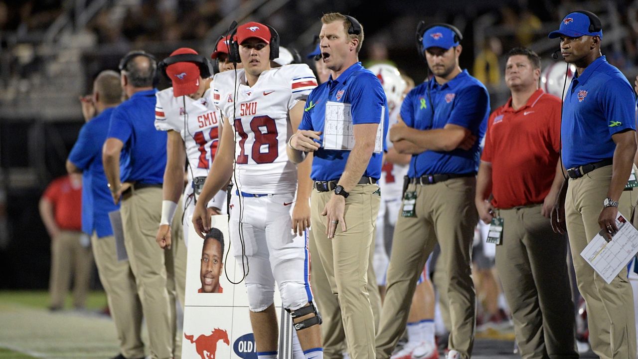 FILE - SMU offensive coordinator Rhett Lashlee, center, calls out instructions from the sideline during the first half of an NCAA college football game against Central Florida Saturday, Oct. 6, 2018, in Orlando, Fla. SMU hired Rhett Lashlee as its new head coach Monday, Mov. 29, 2021, bringing back its former offensive coordinator to replace Sonny Dykes.(AP Photo/Phelan M. Ebenhack, File)