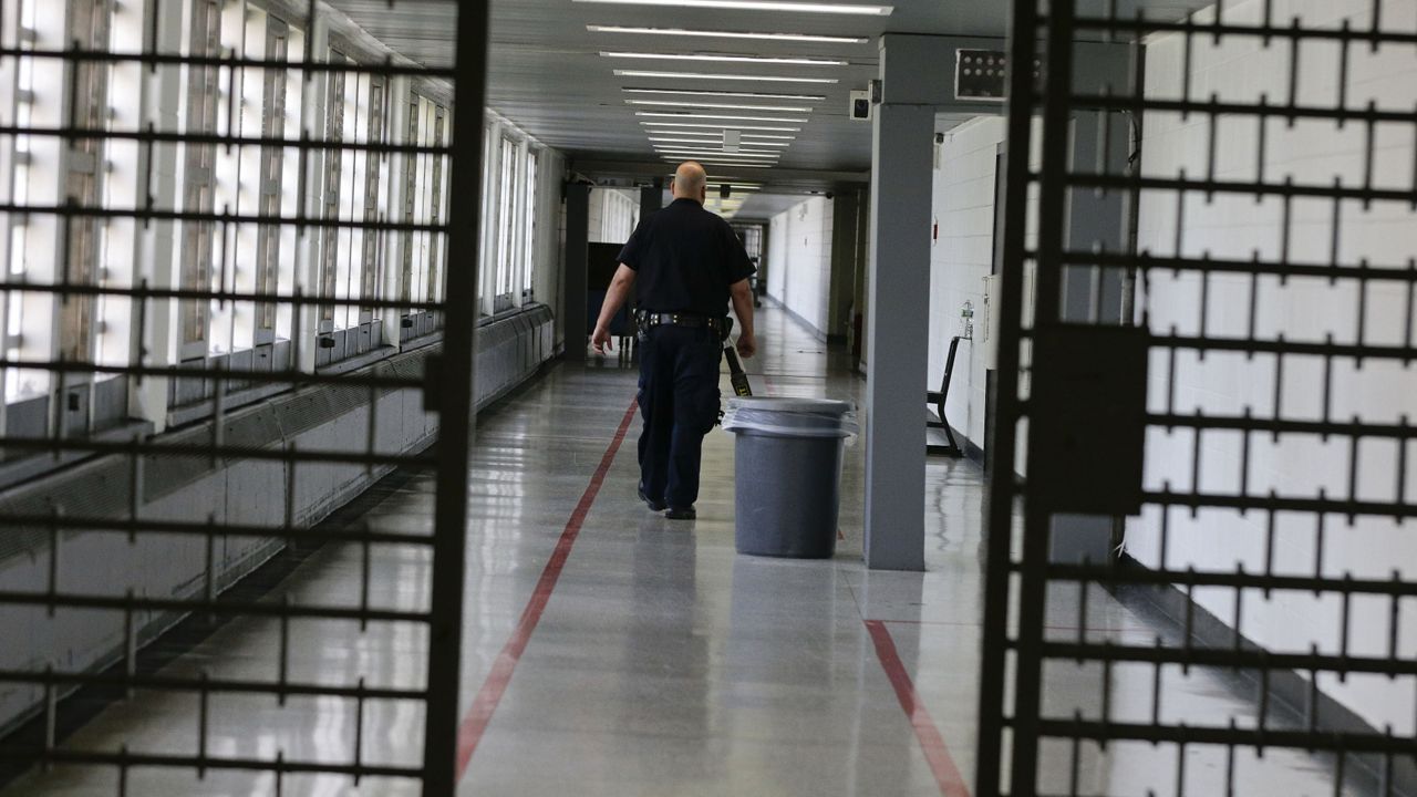 FILE - A Rikers Island juvenile detention facility officer walks down a hallway of the jail, Thursday, July 31, 2014, in New York. (AP Photo/Julie Jacobson, File)