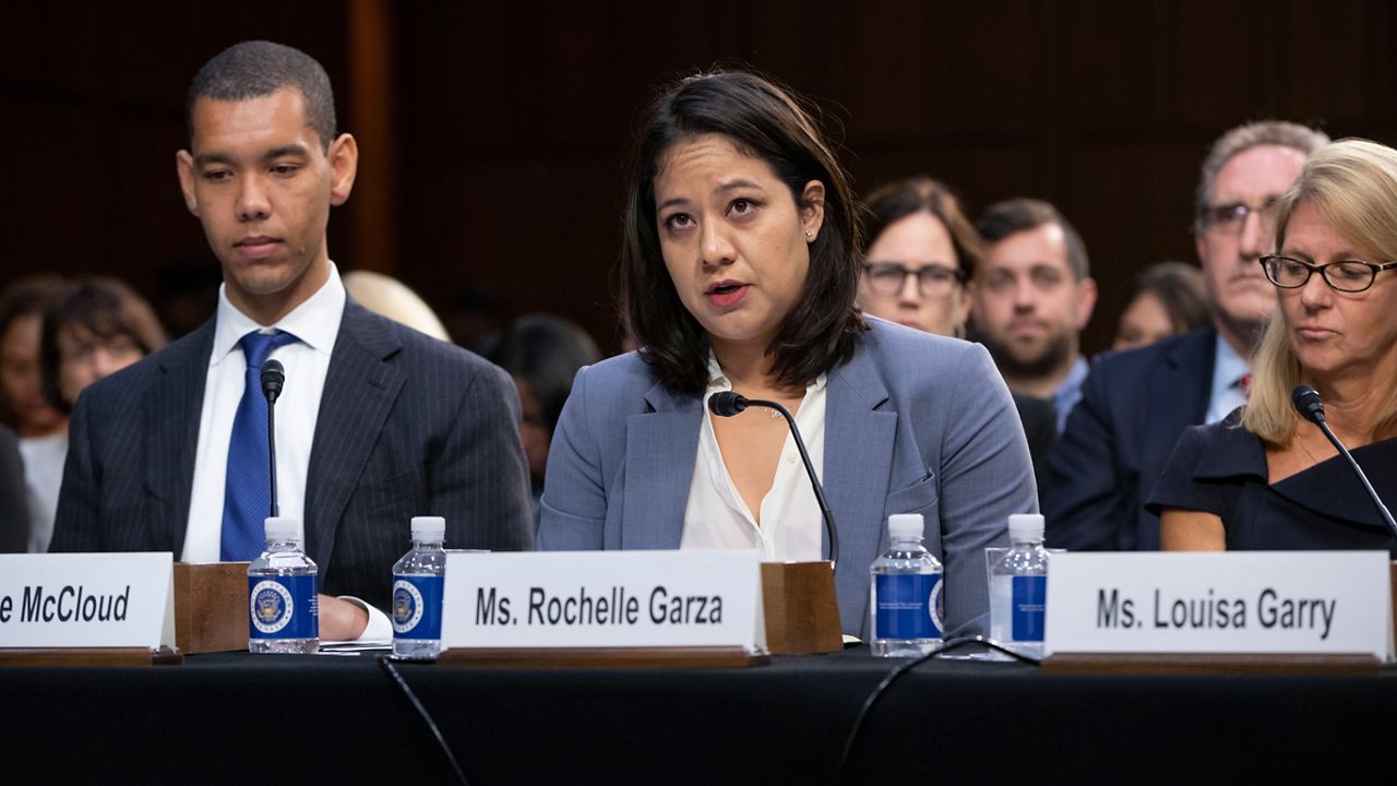 Attorney Rochelle Garza of Brownsville, Texas, joined at left by Luke McCloud, and right by Louisa Garry, describes how she helped an undocumented teenage girl fight for an abortion, as she testifies on a panel of experts and character witnesses before the Senate Judiciary Committee on the final day of the confirmation hearing, on Capitol Hill in Washington, Friday, Sept. 7, 2018. (AP Photo/J. Scott Applewhite)