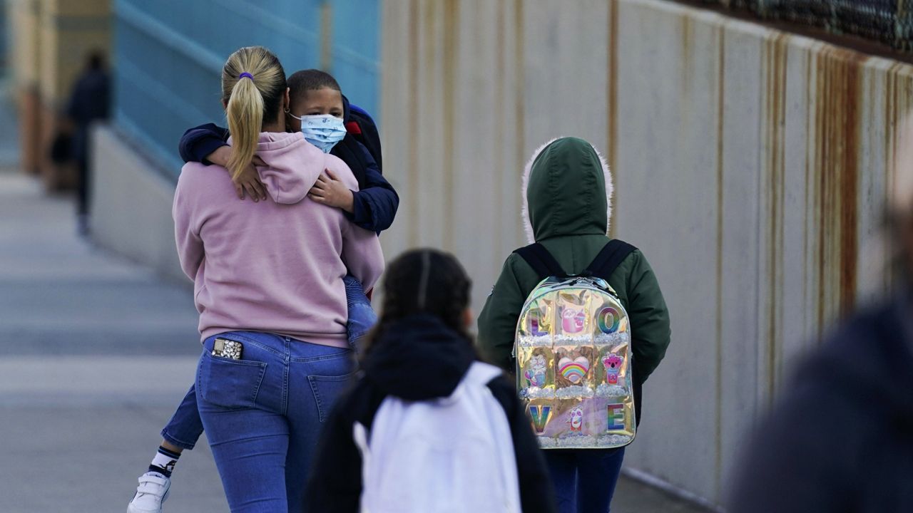 Children and their caregivers arrive for school in New York, March 7, 2022. (AP Photo/Seth Wenig, File)