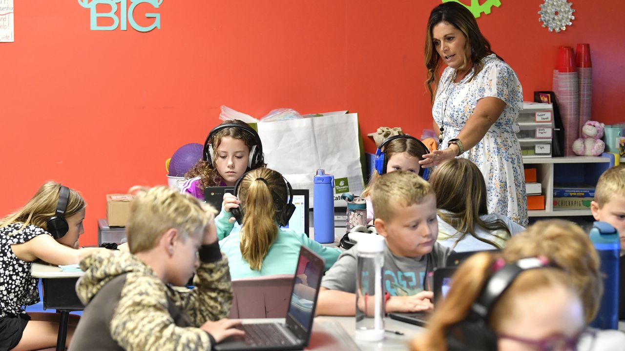 Angela Pike watches her fourth grade students at Lakewood Elementary School in Cecilia, Ky., as they use their laptops to participate in an emotional check-in at the start of the school day, Thursday, Aug. 11, 2022. (AP Photo/Timothy D. Easley)