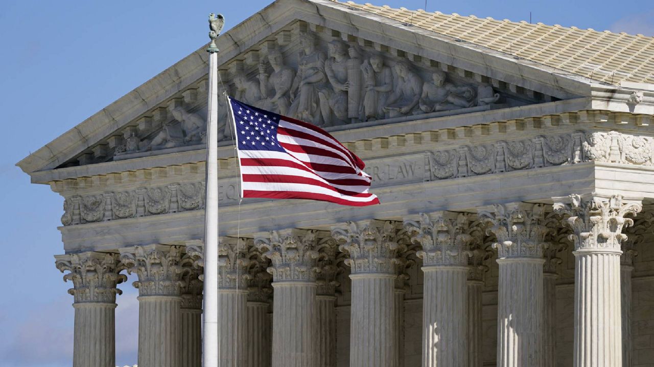 FILE - An American flag waves in front of the Supreme Court building on Capitol Hill in Washington. (AP Photo/Patrick Semansky, File)