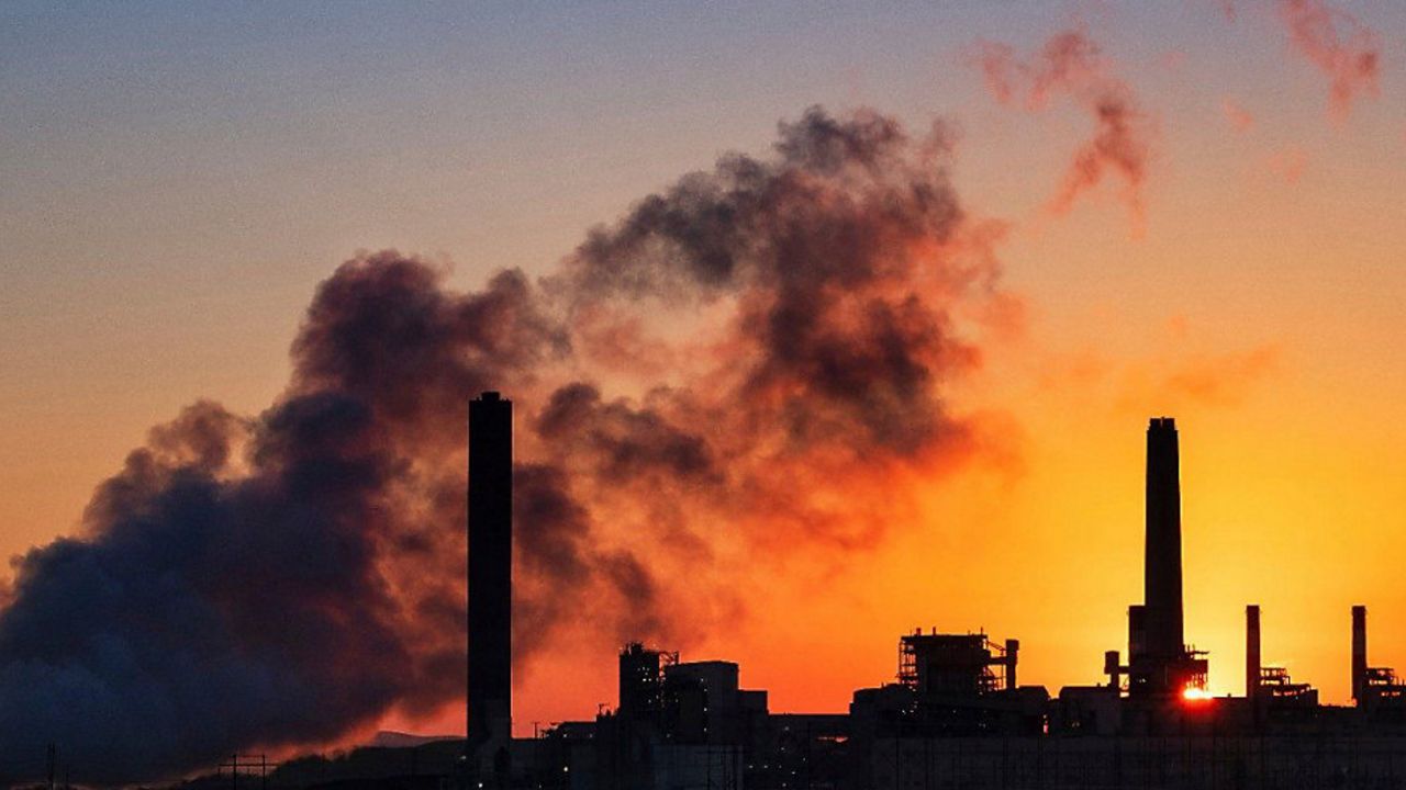 smokestacks at a plant as seen at either dawn or dusk