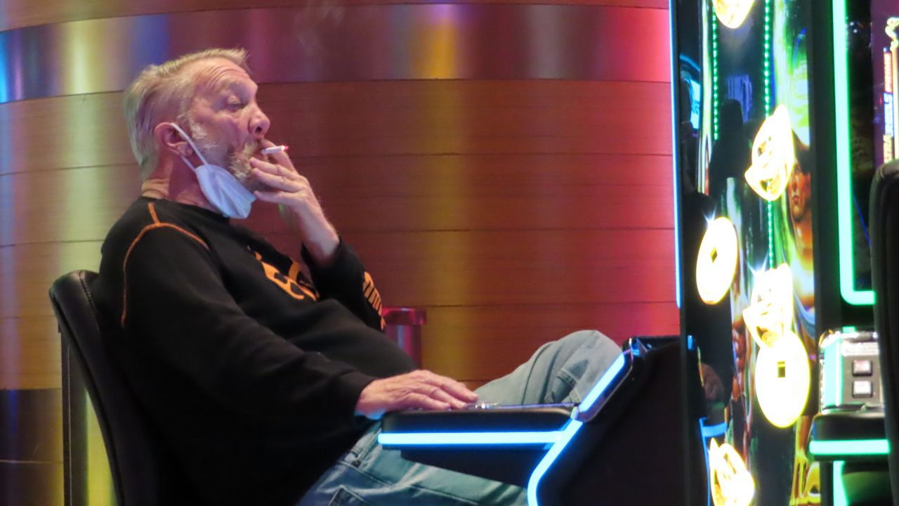 FILE: A man smokes while playing a slot machine at the Ocean Casino Resort in Atlantic City, N.J., Feb. 10, 2022. (AP Photo/Wayne Parry)