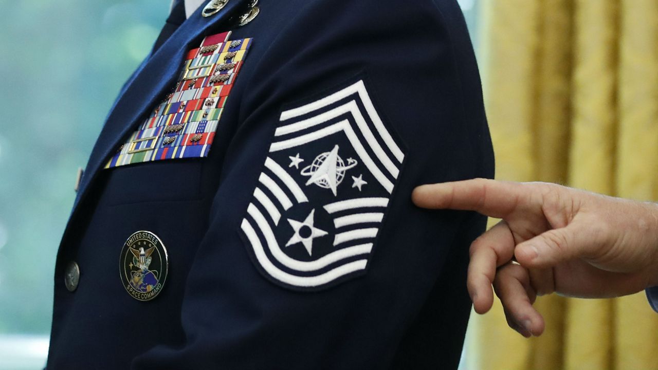 Chief Master Sgt. Roger Towberman displays his insignia during a presentation of the United States Space Force flag in the Oval Office of the White House, Friday, May 15, 2020, in Washington. (AP Photo/Alex Brandon)