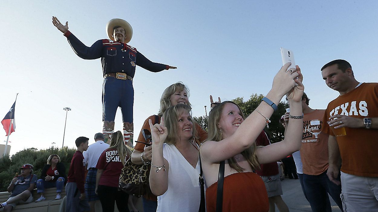 A group takes a photo in front of Big Tex at the State Fair (Associated Press)