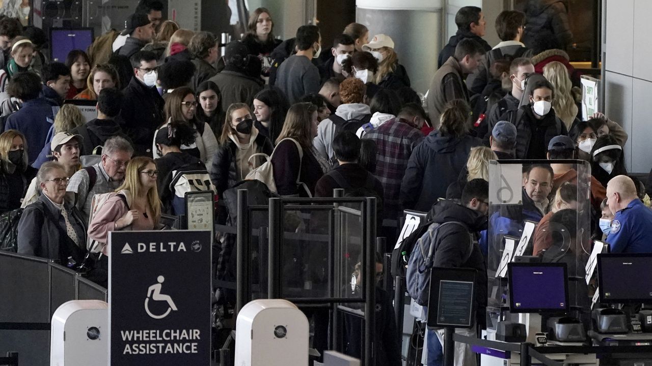 Travelers stand in line at a security checkpoint before boarding their flights the day before Thanksgiving, Wednesday, Nov. 23, 2022, at Logan International Airport in Boston. (AP Photo/Steven Senne)