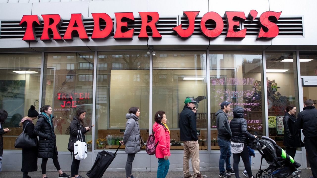Customers line up to enter a Trader Joe's grocery story on Friday, March 13, 2020 in New York.