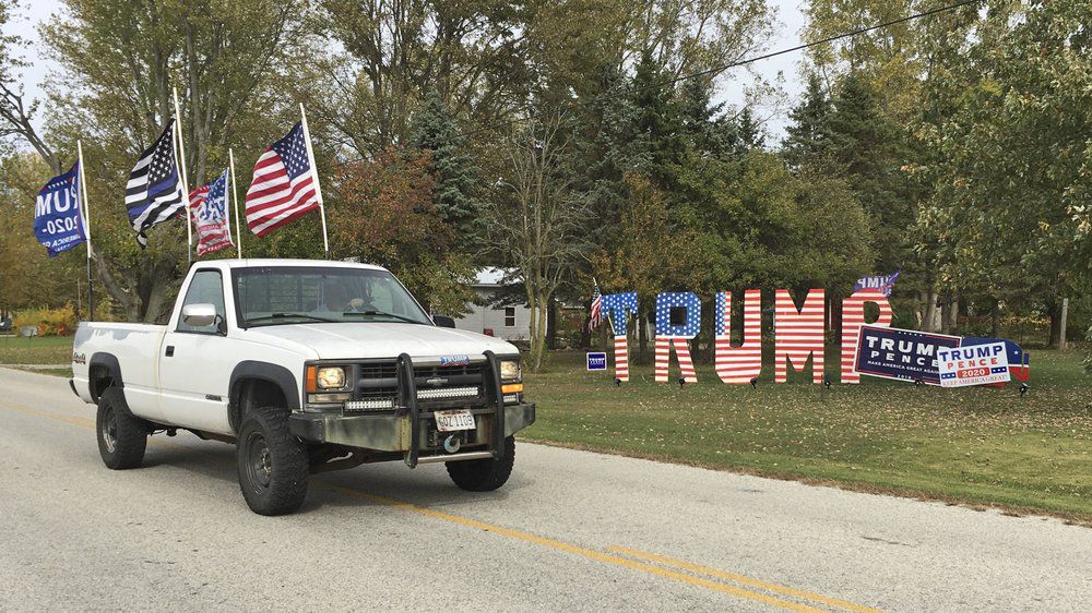 Mike Devore drives his pickup truck past a sign he made to show his support for President Donald Trump in Wayne, Ohio on Wednesday, Oct. 14, 2020. Devore lives in Wood County, an election bellwether that only once since 1964 has not picked the presidential winner. Ohio is again up for grabs in the presidential election. But only a handful of the state's counties have reliably gotten the outcome right going back over many decades. (AP Photo/John Seewer)