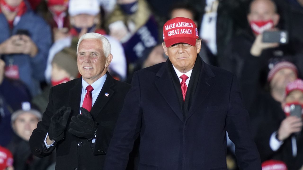 President Donald Trump arrives with Vice President Mike Pence for a campaign rally Monday, Nov. 2, 2020, in Grand Rapids, Mich. (AP Photo/Carlos Osorio)