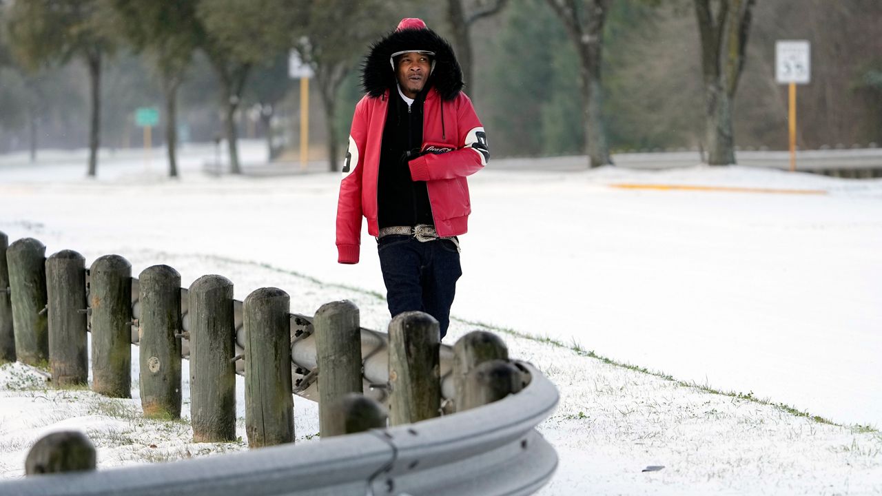 A man walks along a road during the winter storm of February 2021 in Texas. (AP Photo)