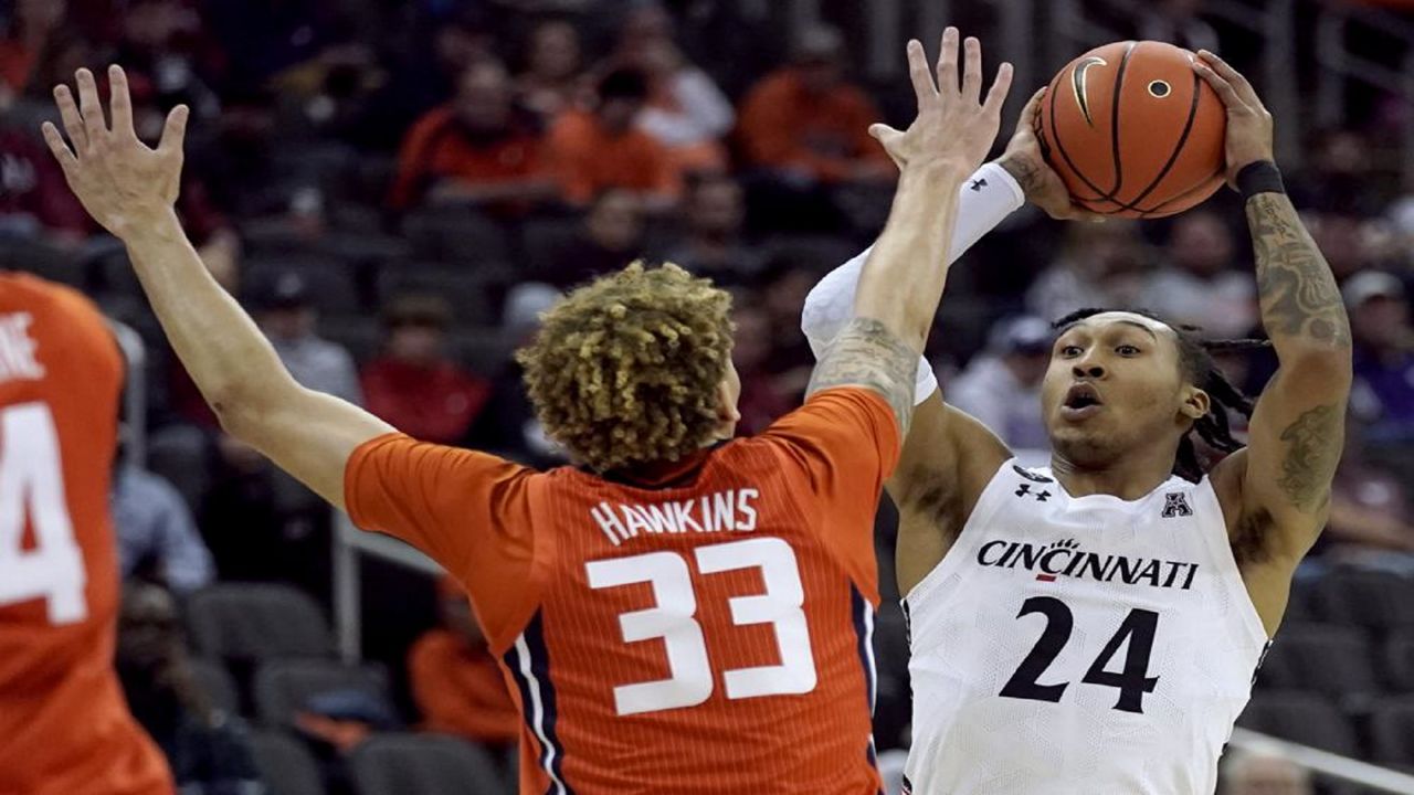 Cincinnati's Jeremiah Davenport (24) looks top pass under pressure from Illinois' Coleman Hawkins (33) during the first half of an NCAA college basketball game Monday, Nov. 22, 2021, in Kansas City, Mo. (AP Photo/Charlie Riedel)