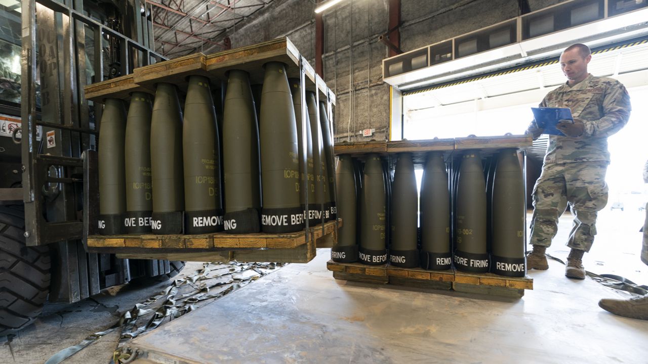 FILE - U.S. Air Force Staff Sgt. Cody Brown, right, with the 436th Aerial Port Squadron, checks pallets of 155 mm shells ultimately bound for Ukraine, April 29, 2022, at Dover Air Force Base, Del. (AP Photo/Alex Brandon, File)