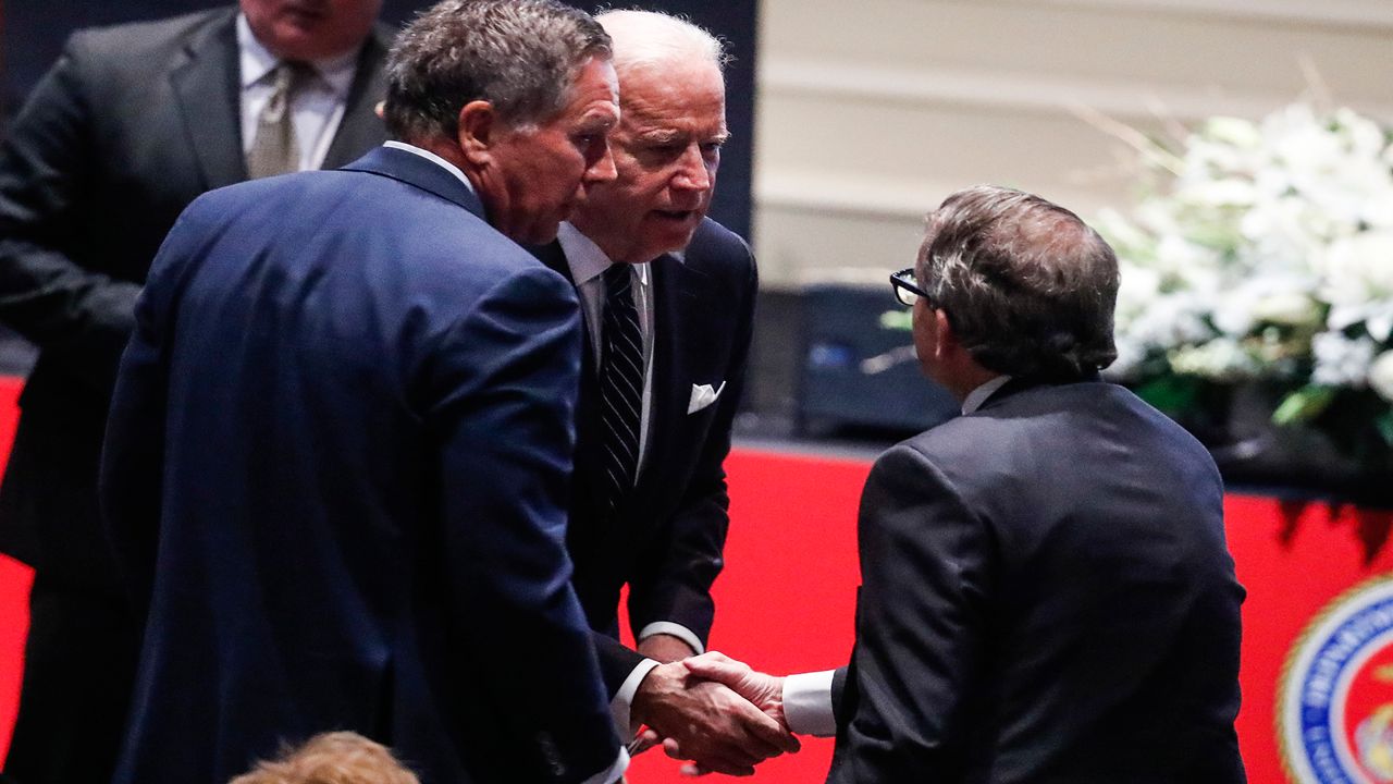 Vice President Joe Biden, center, shakes hands with Ohio Attorney General Mike DeWine, right, alongside Ohio Gov. John Kasich, left, at John Glenn's funeral, Saturday, Dec. 17, 2016, in Columbus, Ohio. The famed astronaut died Dec. 8 at age 95. (AP Photo/John Minchillo)