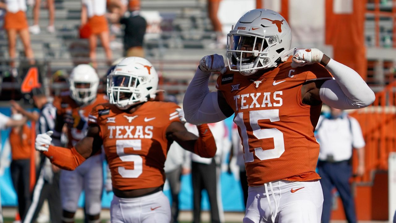 Two UT football players on the field at the West Virginia vs. Texas game. (AP Images)