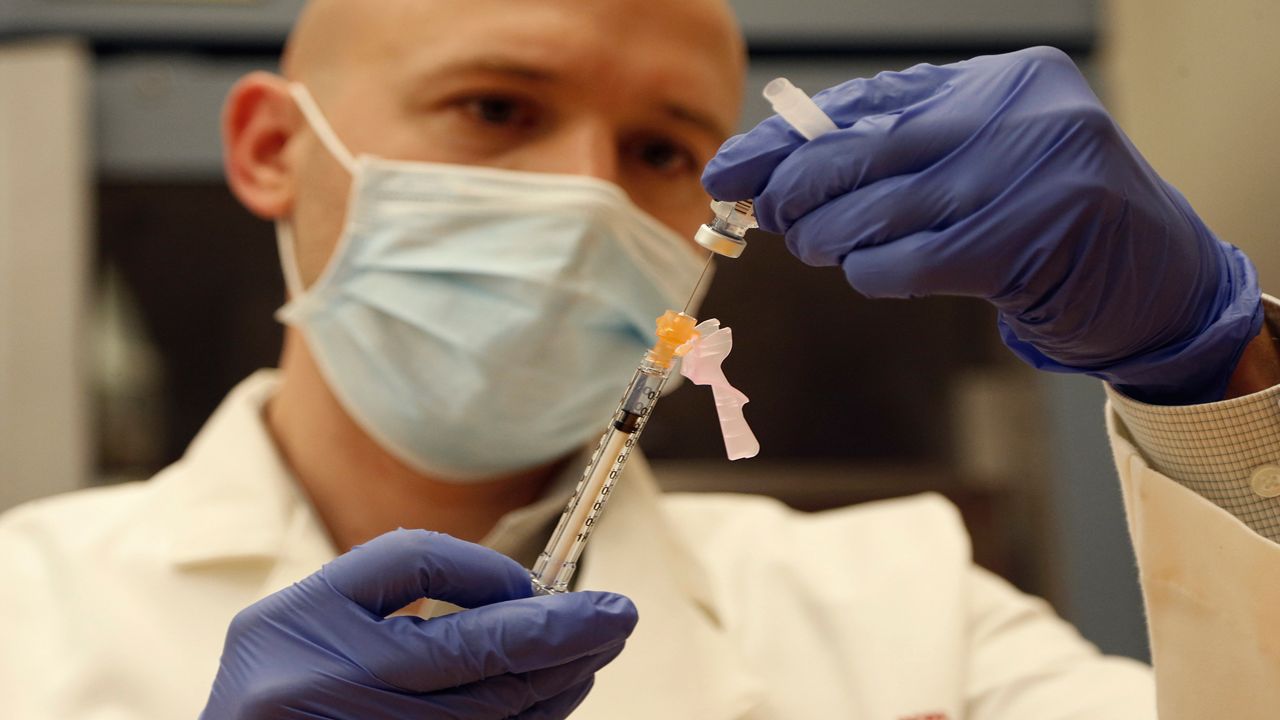 Ohio State employee Steven Loborec fills a syringe with a Pfizer-BioNTech COVID-19 vaccine Monday, Dec. 14, 2020, in Columbus, Ohio. (AP Photo/Jay LaPrete)