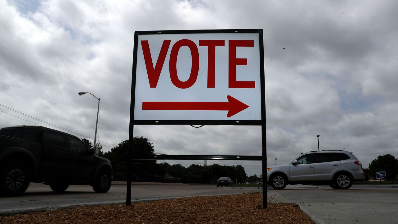 FILE - A sign points where to vote at a polling station, Monday, June 29, 2020, in Plano, Texas. (AP Photo/LM Otero)