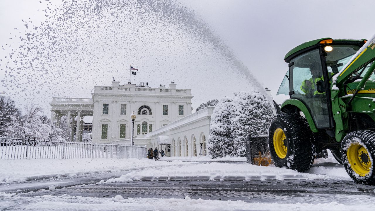 A groundskeeper clears the driveway in front of the West Wing of the White House in Washington, Monday, Jan. 3, 2022. (AP Photo/Andrew Harnik)
